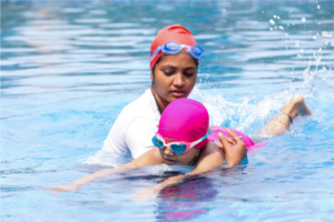 woman teaching girl to swim
